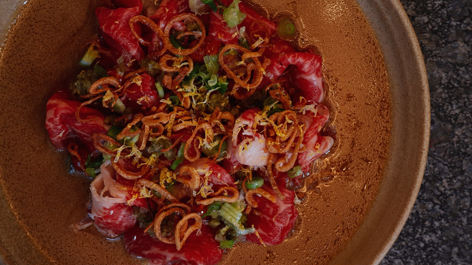 Laminado de Wagyu con chalota crujiente y ralladura de limón